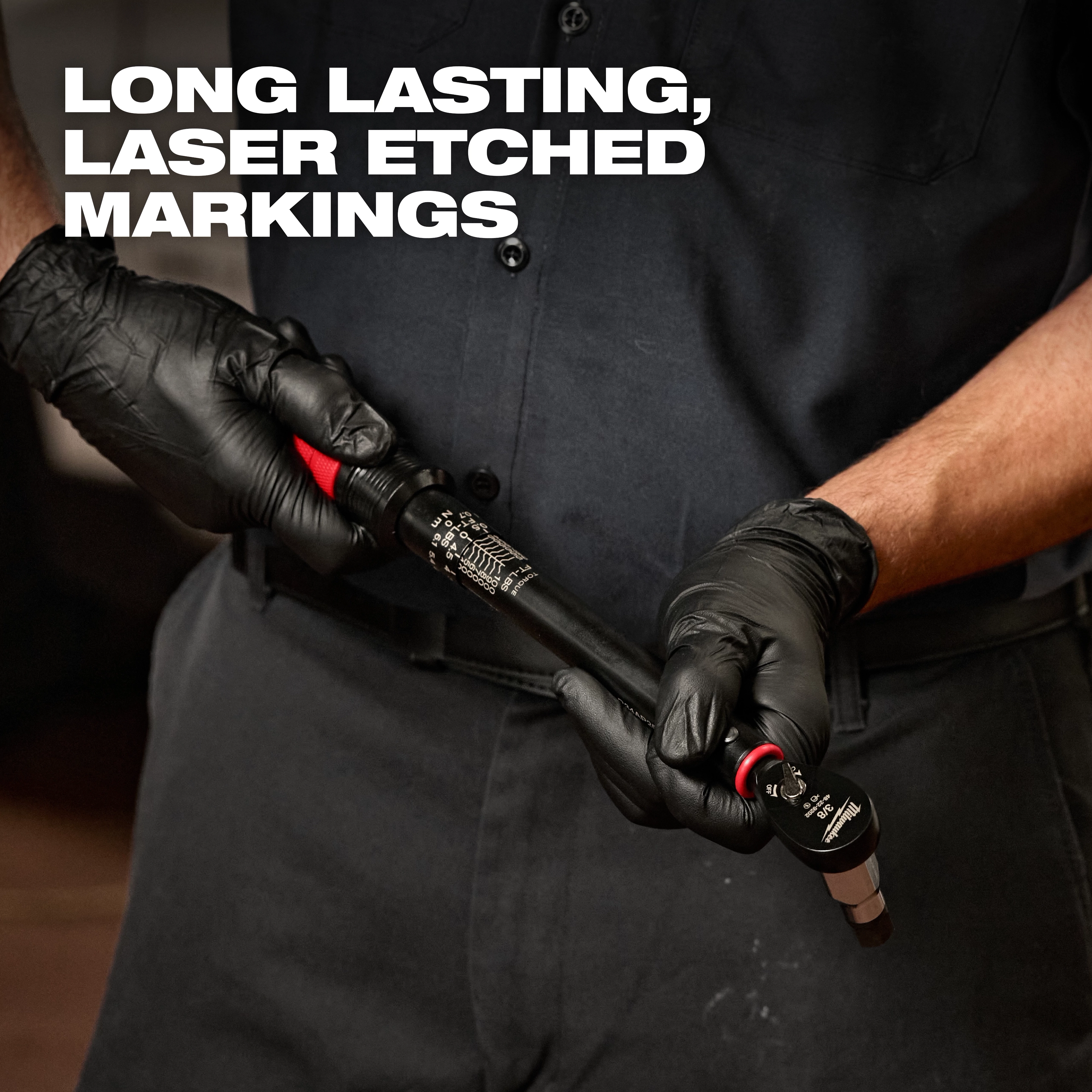 A person wearing black gloves holds a 3/8” Drive Click Torque Wrench (20-100 ft·lbf) featuring long-lasting, laser-etched markings.