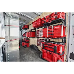 Organized PACKOUT Racking Kit in a van, displaying various red storage boxes and tool organizers securely mounted and neatly arranged.