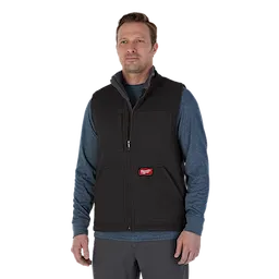 Man wearing the black heavy duty sherpa-lined vest over the blue pullover hoodie