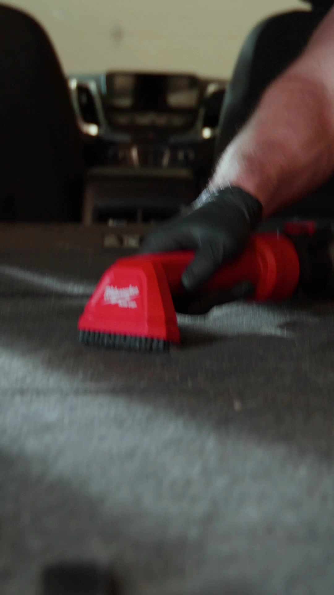 Milwaukee AIR-TIP Automotive Detail Brush in use inside a car.