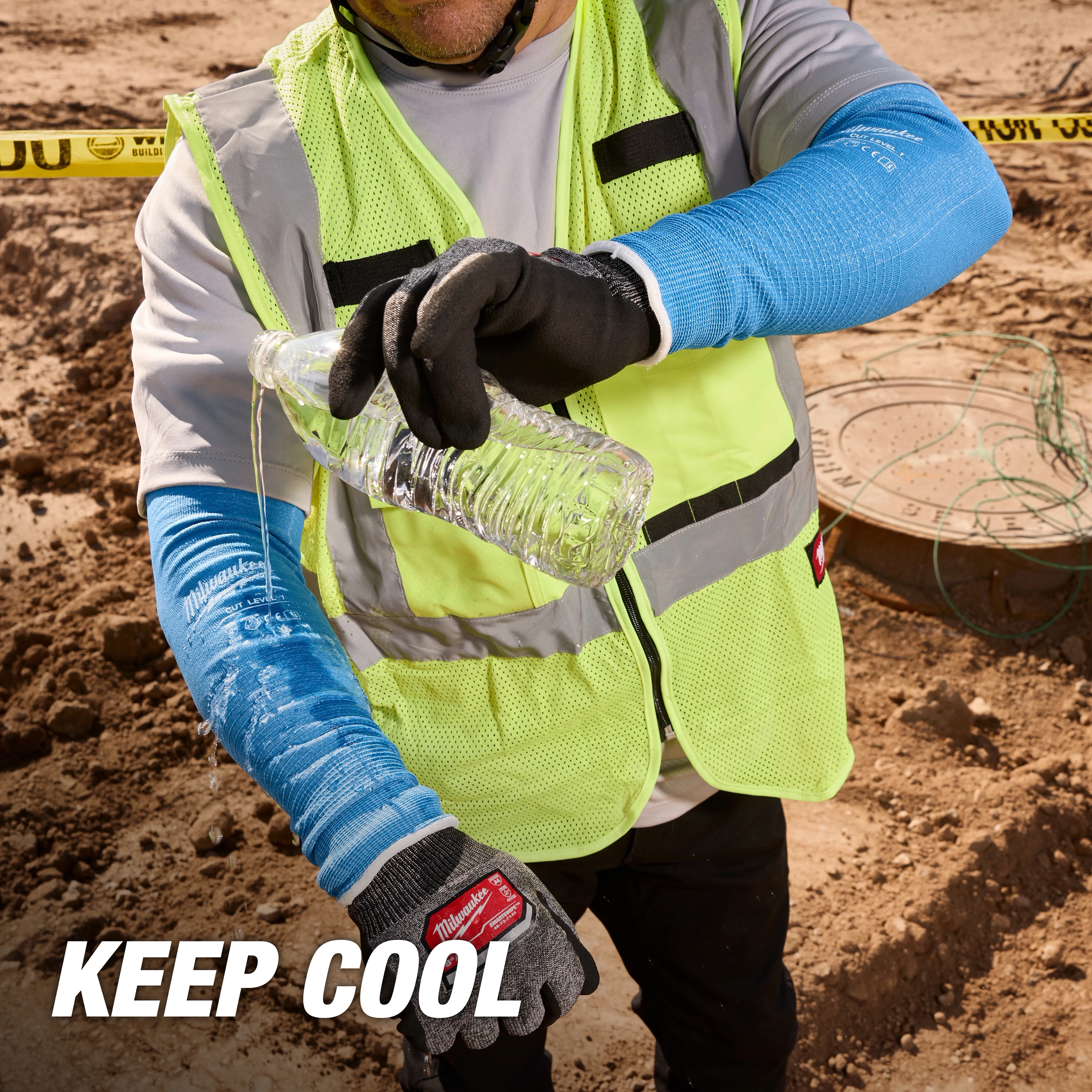 Worker in a neon vest and Cooling Cut Level 1 Protective Sleeves - 16" pours water on a sleeve at a construction site. Text reads "KEEP COOL."