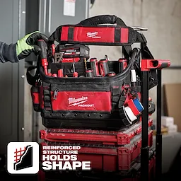 App%20Shot%20Overlay: A Milwaukee Packout tool bag filled with various tools, placed atop a stack of red toolboxes. Text states "Reinforced Structure Holds Shape."