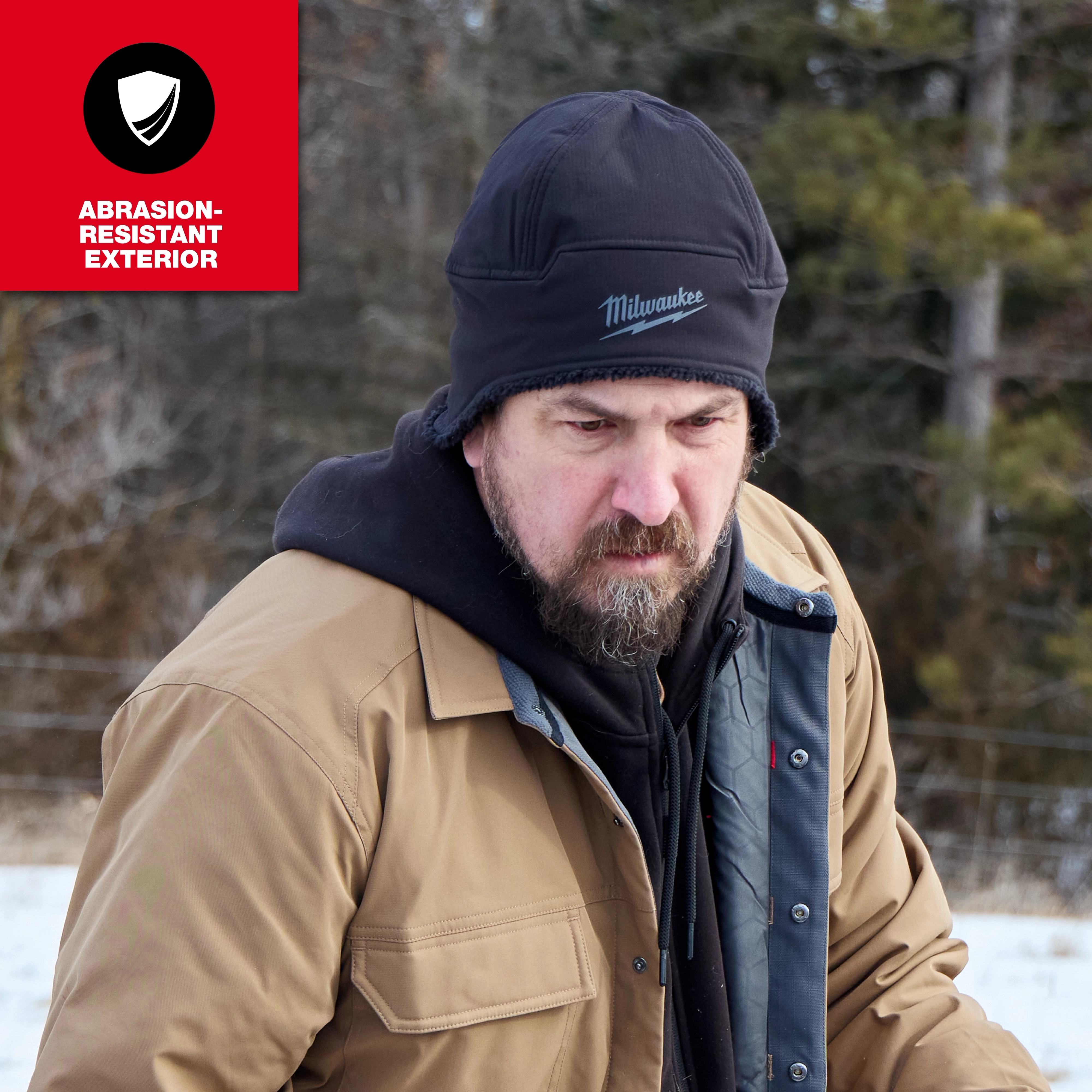 Person outdoors in winter wearing a Milwaukee Sherpa-Lined Beanie with layered work jacket.