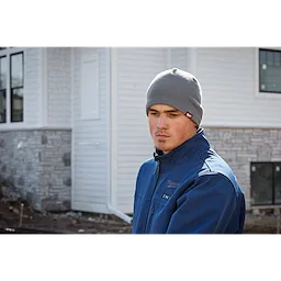 Image of a man on a jobsite wearing the Milwaukee Fleece-Lined Beanie in gray