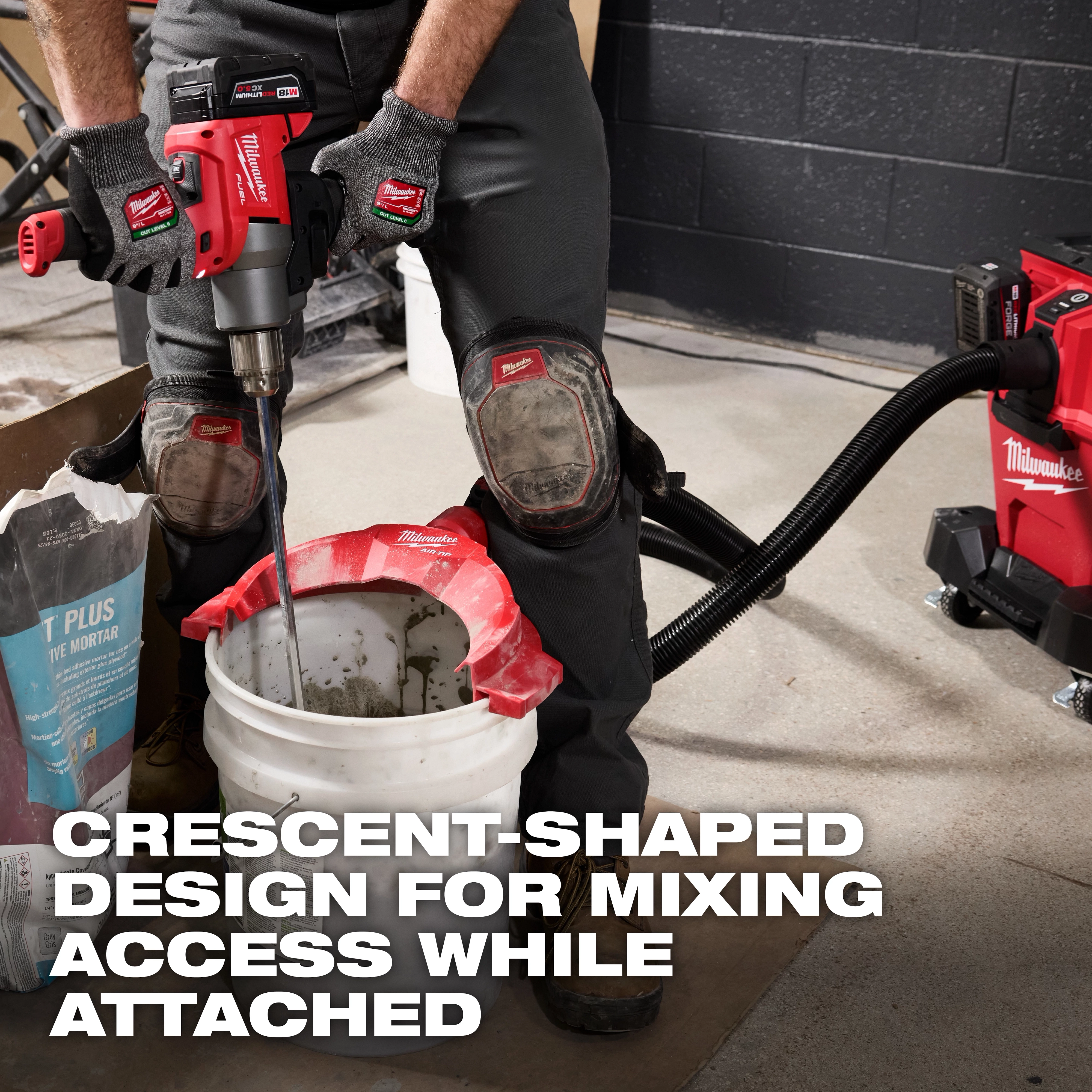 Man using a power tool with knee pads, demonstrating the AIR-TIP Bucket Topper Dust Collector attached to a white bucket.