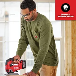 Man using a jigsaw while wearing a dark green GRIDIRON Pocket Long Sleeve T-Shirt. Text overlay reads "Durable, reliable fabric."