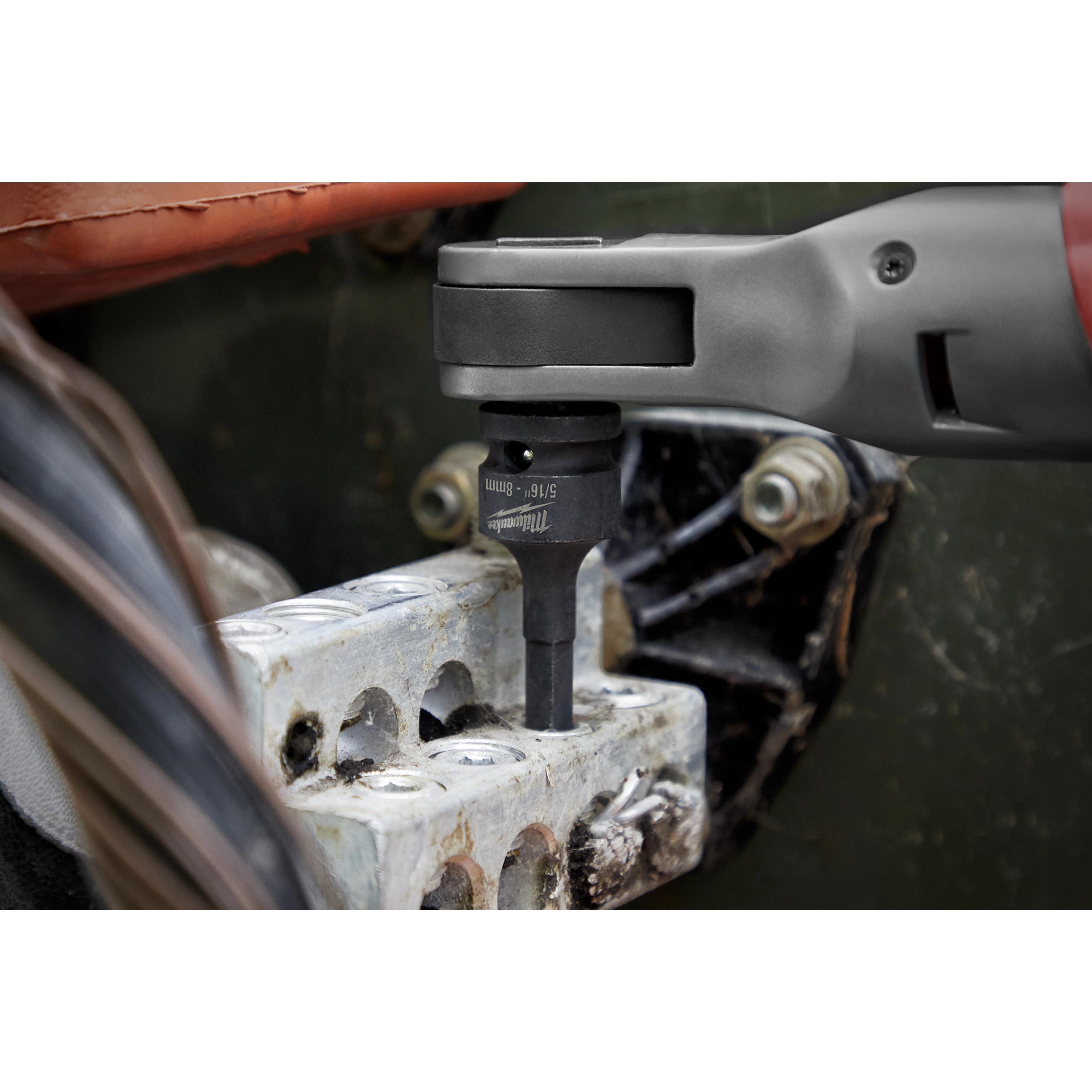 Close-up of a power tool using the Shockwave Lineman's 6PT 9/16" x 3/4 2-in-1 Socket to tighten bolts on an industrial component.