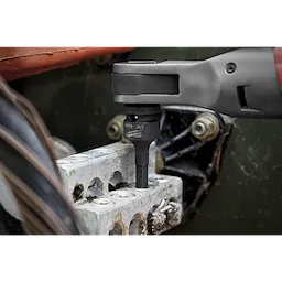 Close-up of a power tool using the Shockwave Lineman's 6PT 9/16" x 3/4 2-in-1 Socket to tighten bolts on an industrial component.