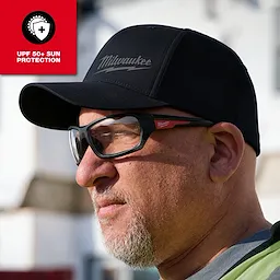 WORKSKIN Performance Fitted Hat with custom sweat-wicking fabric, black color, worn outdoors.