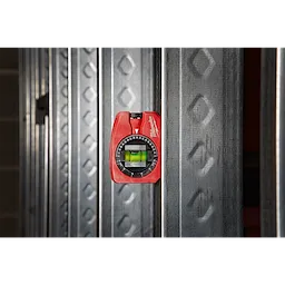 Milwaukee Pocket Level magnetically attached to a steel beam, featuring a red body and a circular vial for precise leveling.