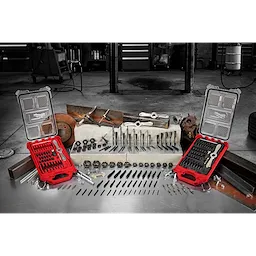 The March 2023 Taps and Dies Family product displays various taps and dies laid out on a workbench, accompanied by two red carrying cases. Behind it are workshop tools and machinery. Items include drill bits, screw extractors, tap wrenches, and dies, organized to show different sizes and uses.